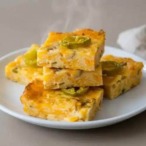 Golden baked Texas Fudge squares topped with jalapeño slices in a baking dish