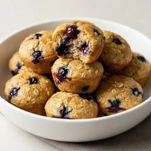 Golden Pancake Poppers studded with fresh blueberries on a breakfast plate.