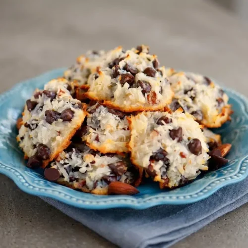 Baked flourless Almond Joy cookies featuring toasted shredded coconut, melted chocolate chips, and whole almonds.