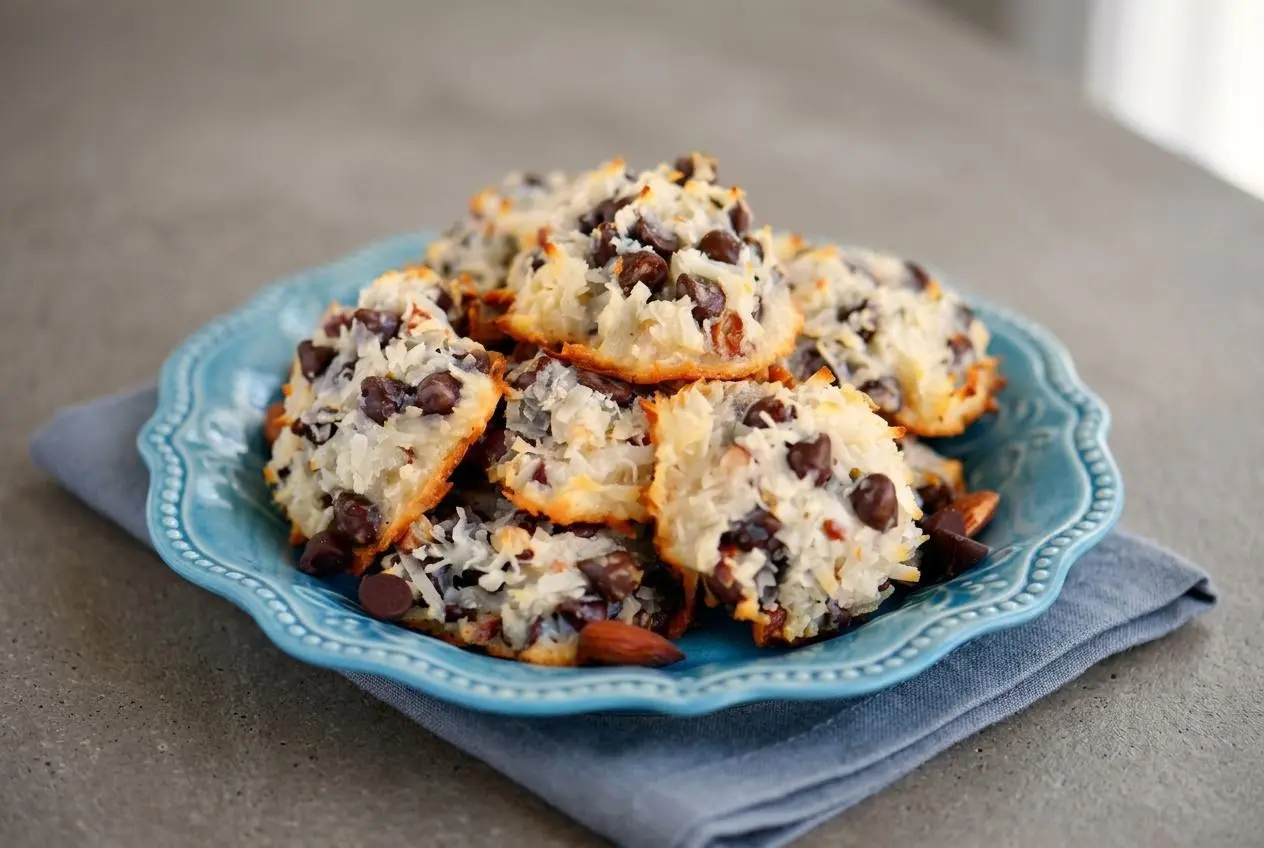 Baked flourless Almond Joy cookies featuring toasted shredded coconut, melted chocolate chips, and whole almonds.