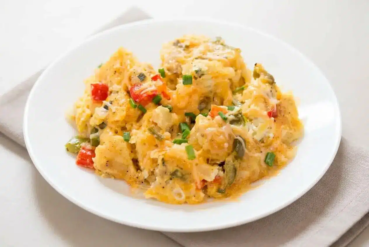 Crock Pot egg scramble with fluffy eggs, golden melted cheese, and tender potatoes topped with fresh chives.