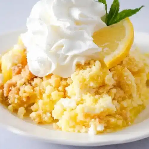 Lemon dump cake with a golden brown crust and a creamy lemon layer served in a baking dish.