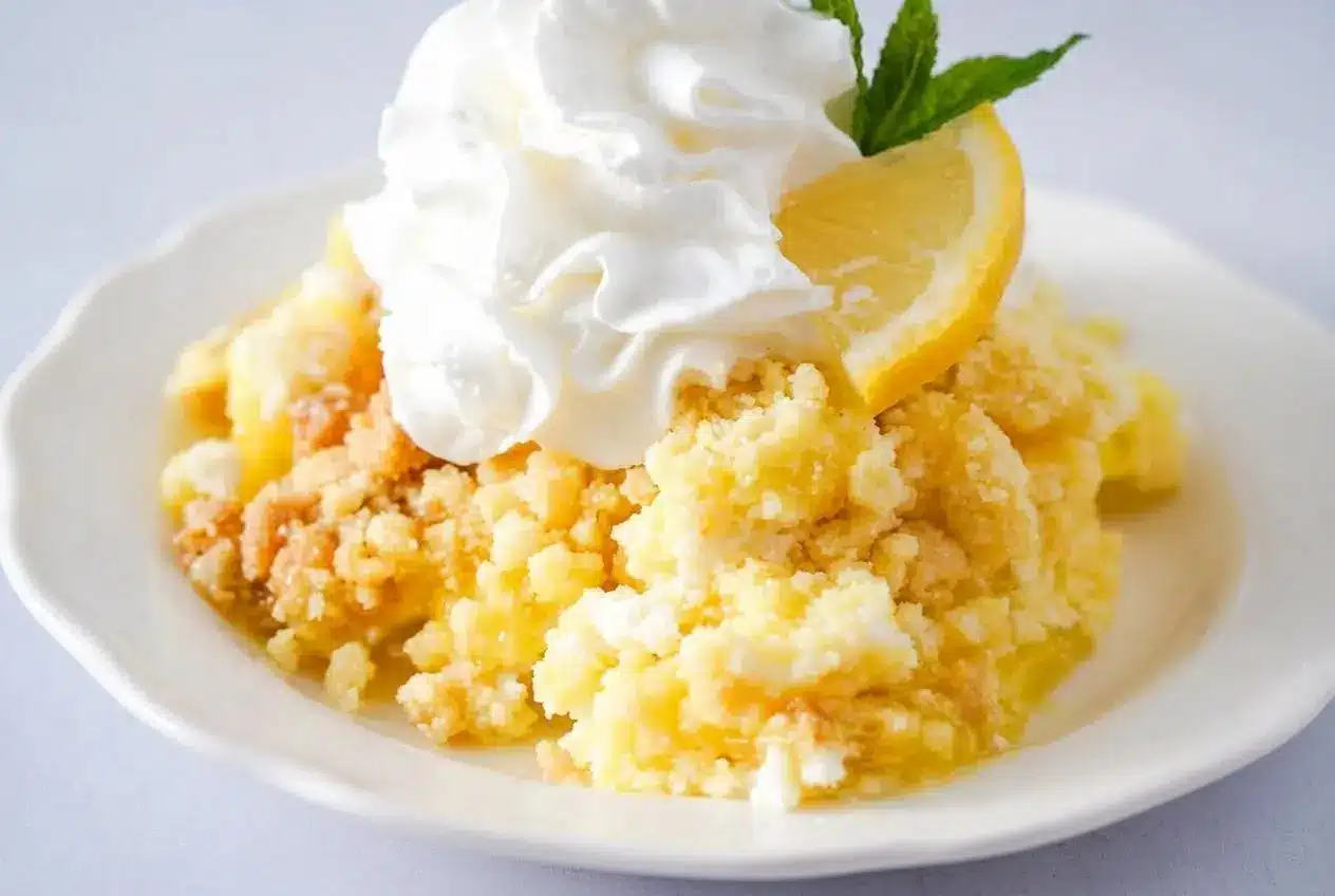 Lemon dump cake with a golden brown crust and a creamy lemon layer served in a baking dish.