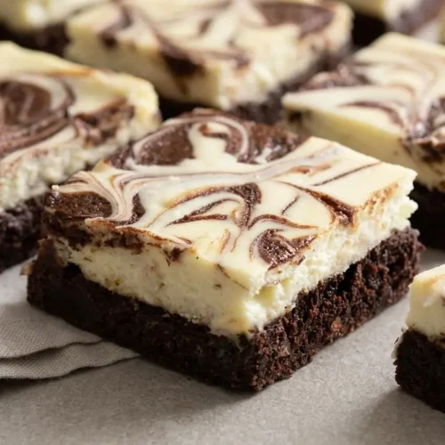 Swirled cheesecake brownie bars with a fudgy dark chocolate base and a creamy vanilla cream cheese topping.