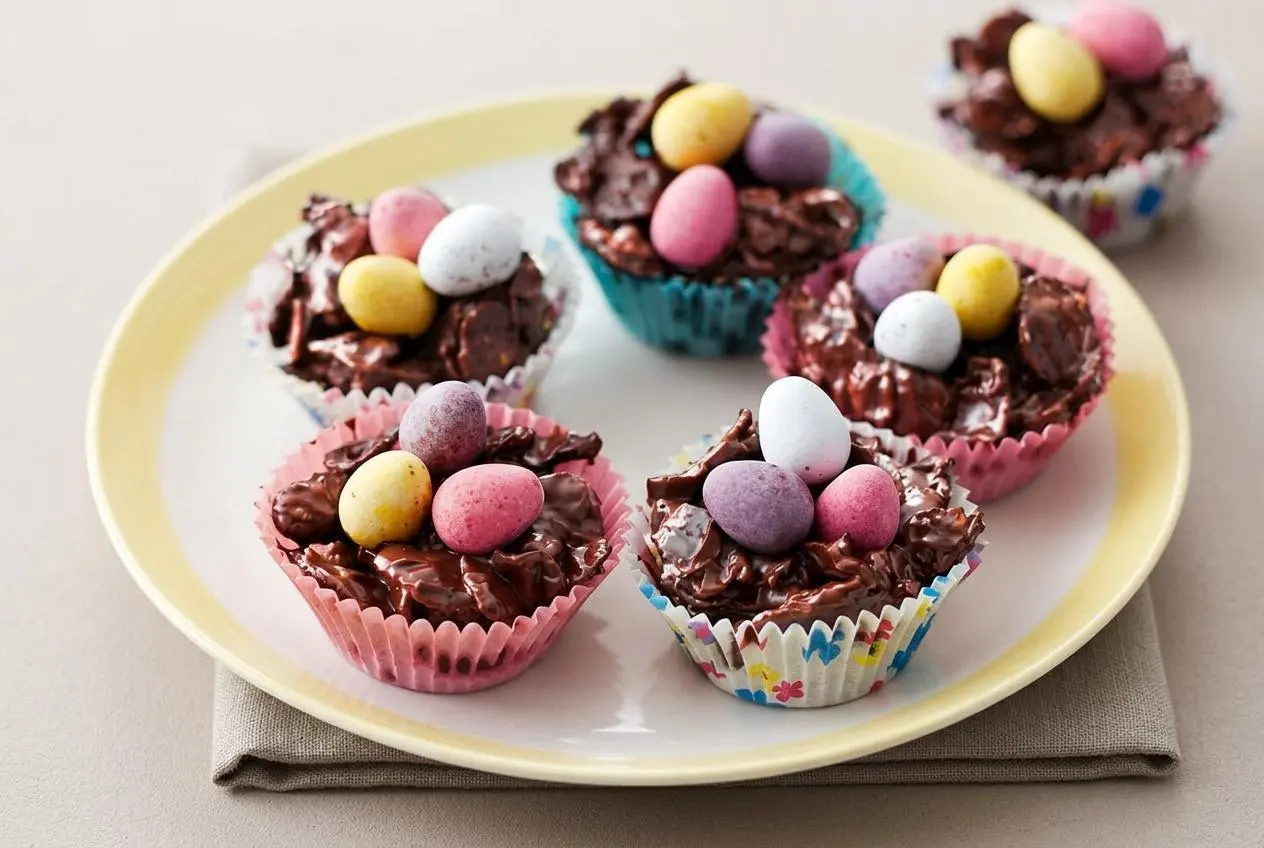 A finished Chocolate Easter egg nest cake made of crispy cornflakes coated in glossy melted chocolate and topped with three mini chocolate