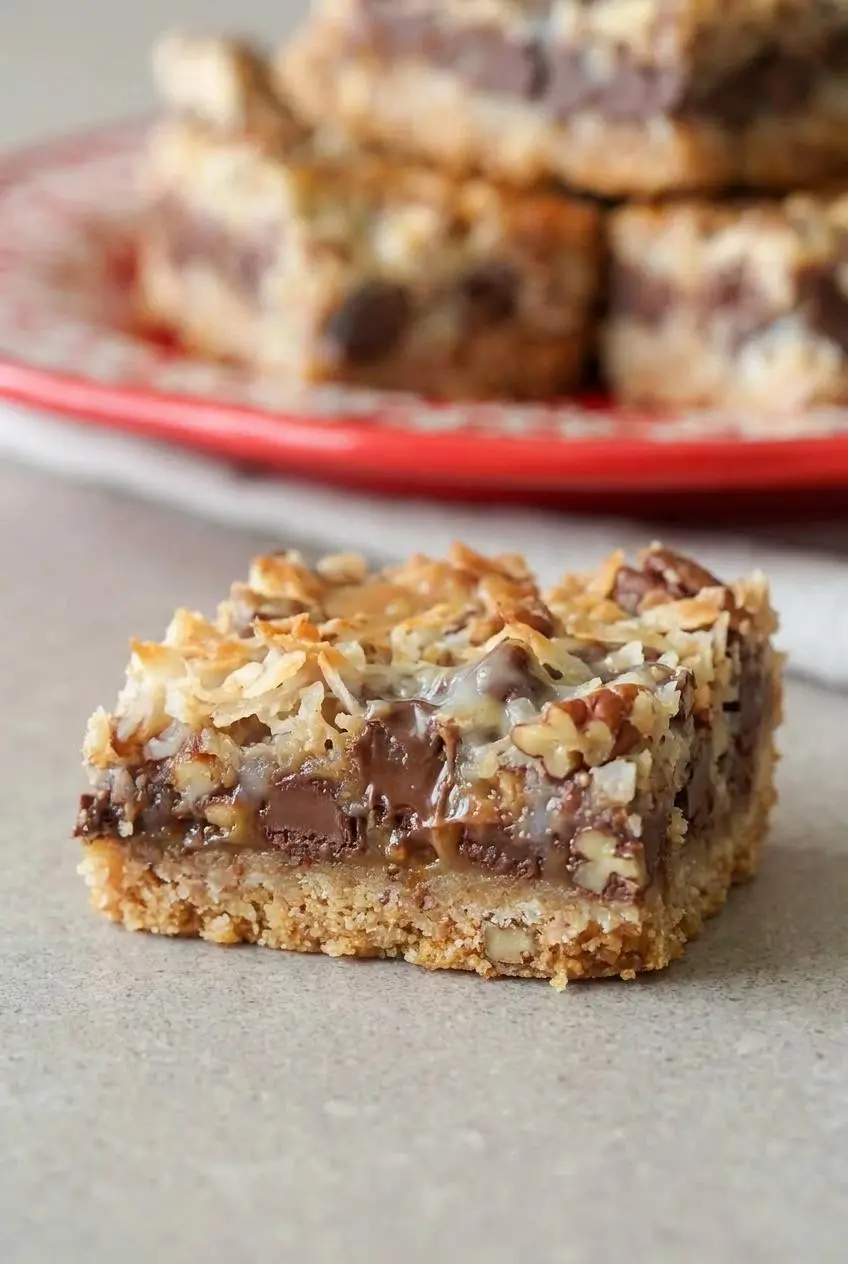 Detailed close-up of a Hello Dolly bar showing toasted coconut, melted chocolate chips, and graham cracker crust.