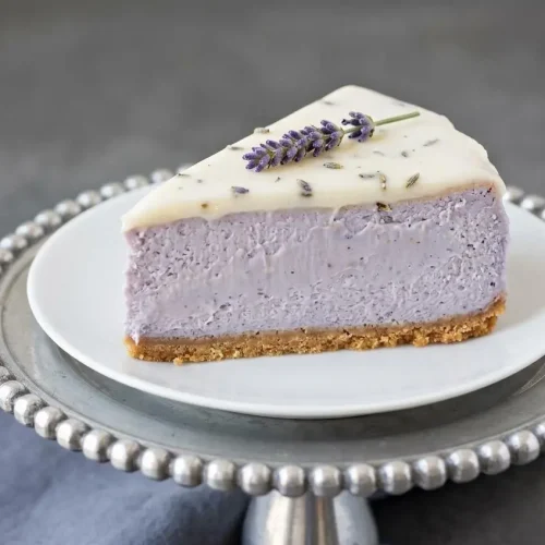 Baked honey lavender cheesecake with a velvety pale violet filling, golden graham cracker crust, and glossy topping.