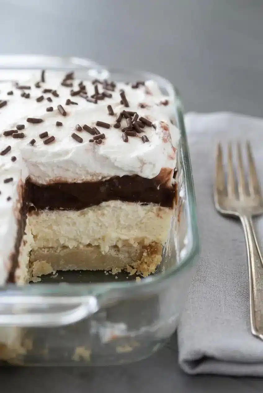 Side view profile of the layered chocolate dessert in a baking dish showing the four distinct, textured layers.