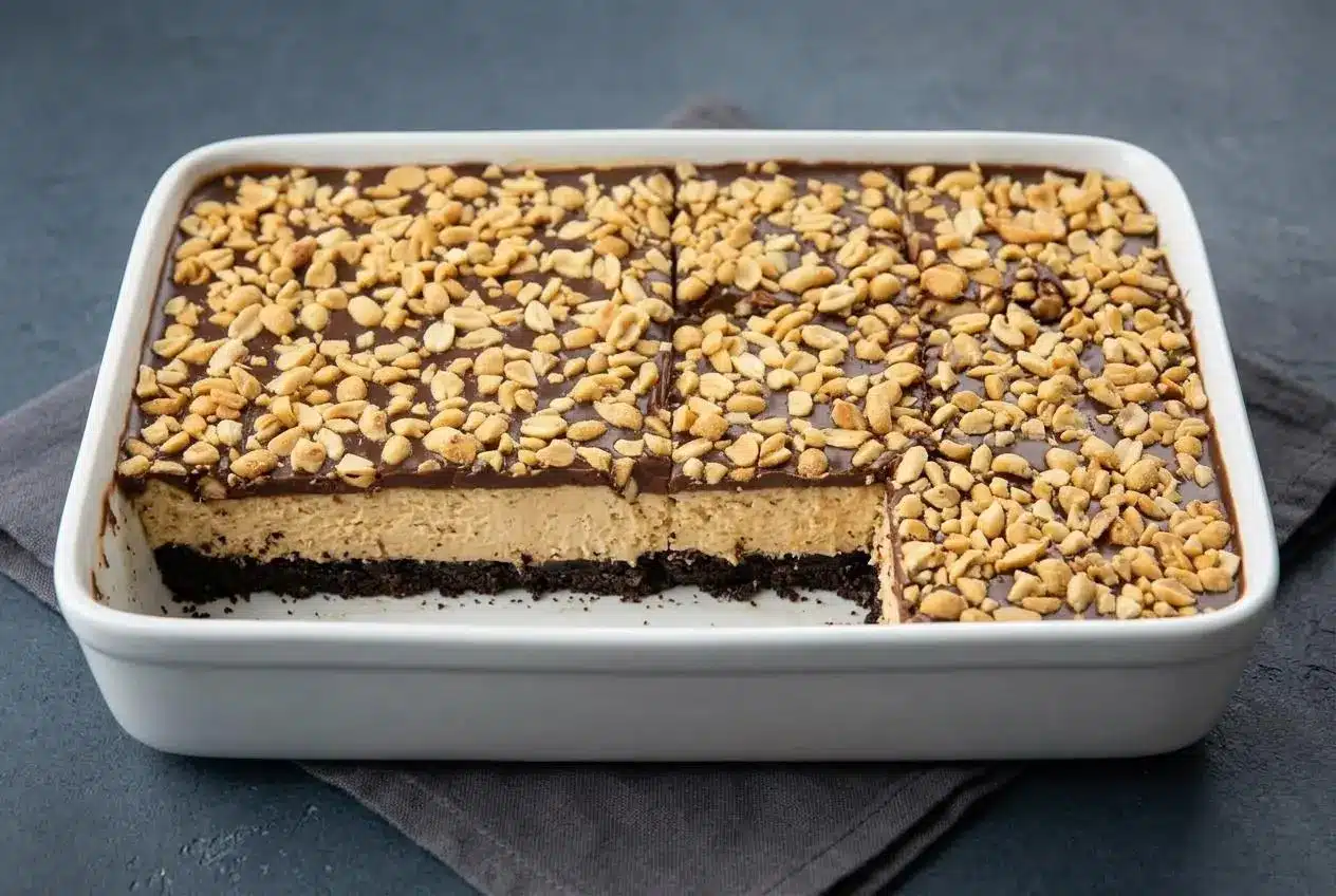 Slices of no bake buckeye cheesecake bars showing chocolate cookie crust, peanut butter filling, and chocolate ganache.