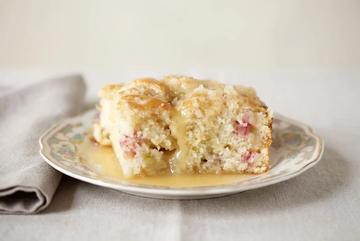 Rhubarb Streusel Cake with Warm Vanilla Sauce featuring a crackly sugar topping and a glossy drizzle
