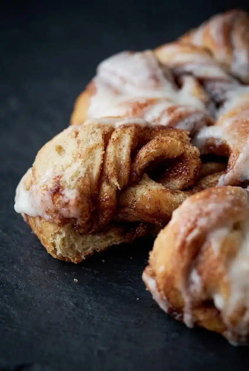 Close-up texture of a pulled-apart sourdough cinnamon star point showing the soft, airy crumb and caramelized filling layers.