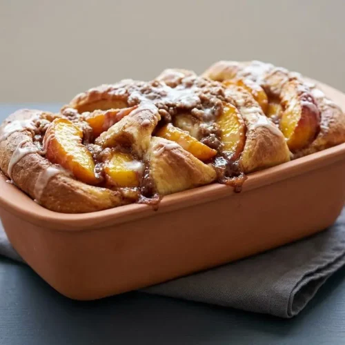 Sourdough Peach Pull-Apart Bread with a golden-brown streusel crust and sweet vanilla glaze.