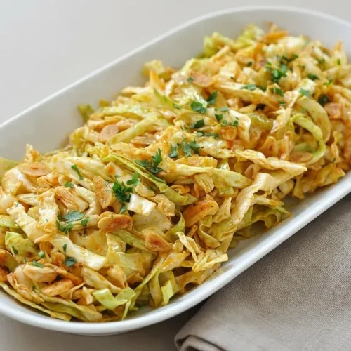 Spanish Cabbage Salad with crisp green cabbage ribbons, golden garlic slices, and paprika olive oil dressing.