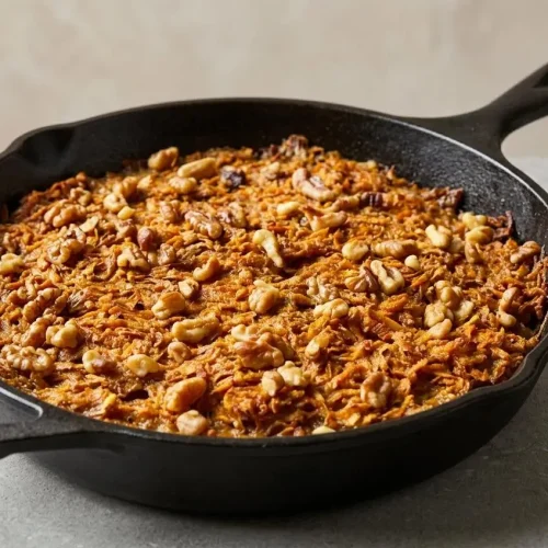 Freshly baked Sweet Potato Pone showing deeply caramelized edges and a dense, spiced pudding-like center.