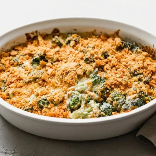 Baked broccoli cheese casserole with creamy cheddar sauce and a crisp, golden cracker topping.
