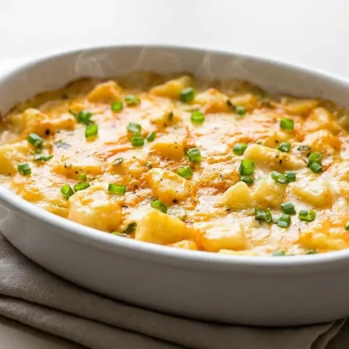 Baked cheesy potatoes recipe casserole bubbly and golden-brown in a baking dish.