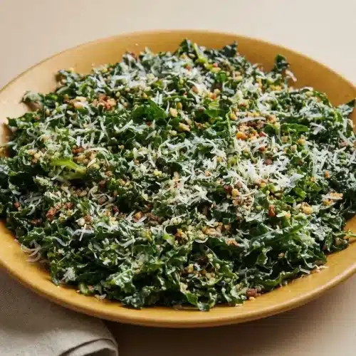 Tender kale salad recipe tossed with lemon garlic dressing, grated Pecorino Romano, and crunchy breadcrumbs.