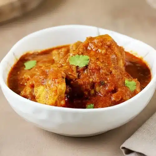 Rich chicken curry with tender meat in a thick, glossy tomato onion gravy.