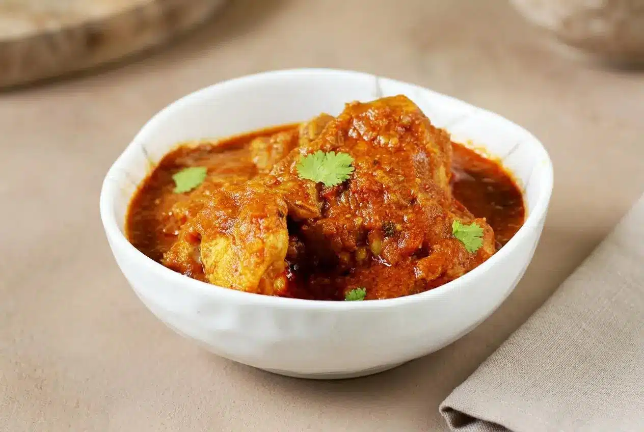 Rich chicken curry with tender meat in a thick, glossy tomato onion gravy.