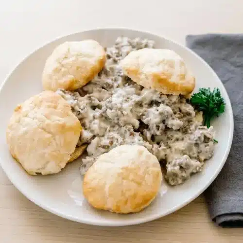 Smooth and creamy sausage gravy recipe with flecks of coarse black pepper in a cast iron skillet.