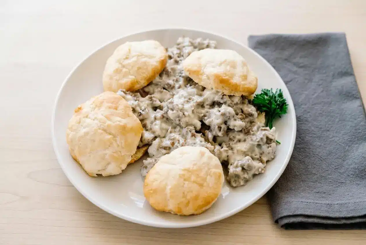Smooth and creamy sausage gravy recipe with flecks of coarse black pepper in a cast iron skillet.