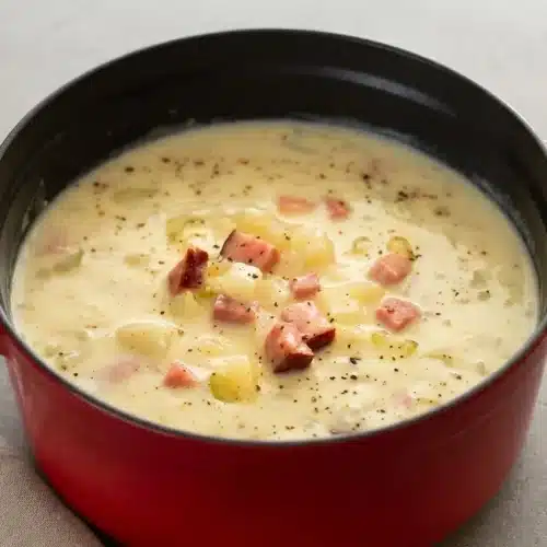 Creamy ham and potato soup served in a ceramic bowl with tender potato cubes and savory diced ham.