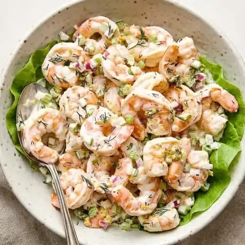 Chilled shrimp salad recipe with poached pink shrimp, crisp celery, and creamy lemon dill dressing in a bowl.