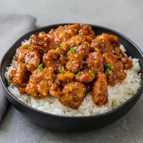 Crispy pan-fried General Tso’s Chicken Recipe coated in a glossy sweet and tangy garlic ginger glaze.