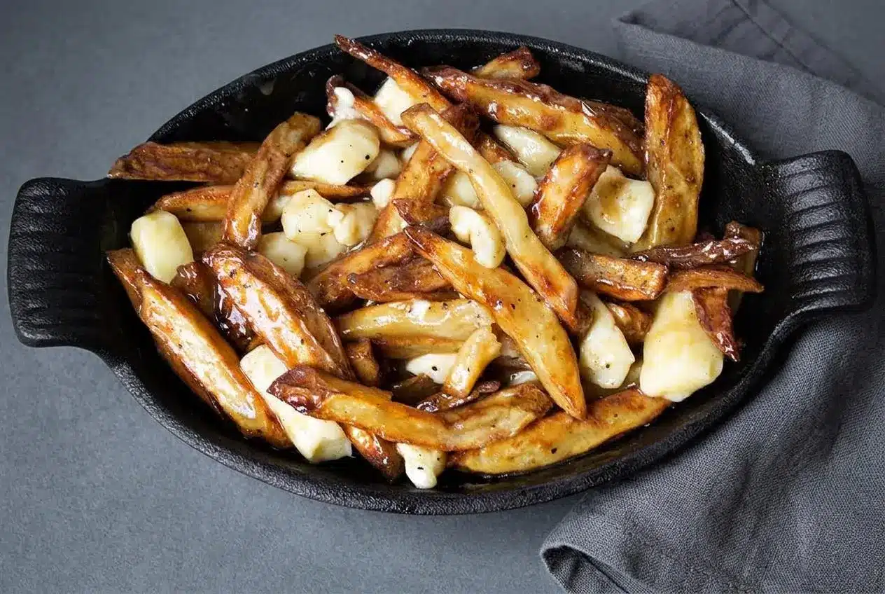 Crisp double-fried russet fries topped with white cheddar cheese curds and glossy brown poutine recipe gravy.
