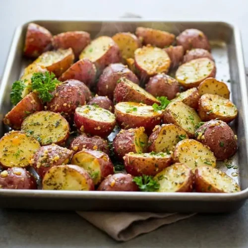 Halved roasted red potatoes with crispy golden edges, melted parmesan cheese, and fresh parsley.