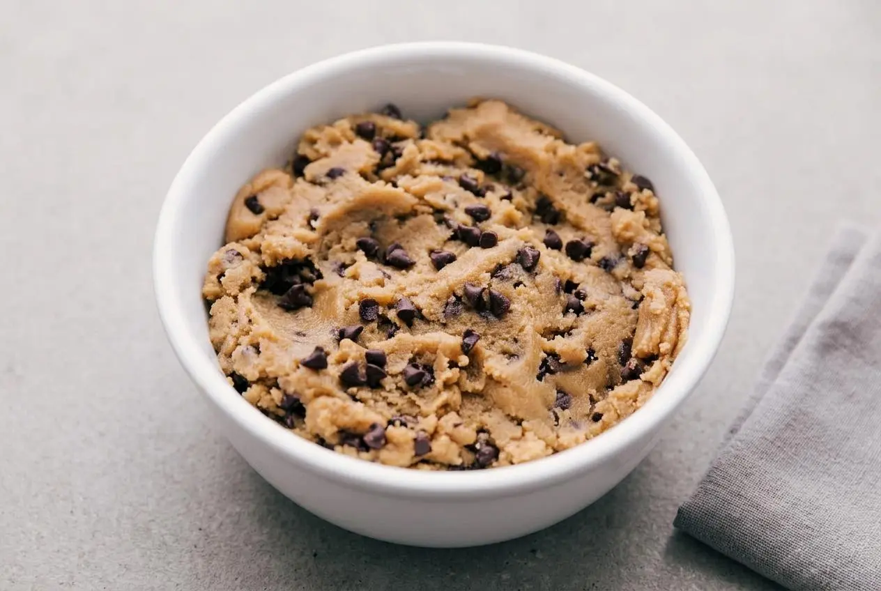 Scoop of creamy edible cookie dough recipe loaded with mini chocolate chips in a small bowl.