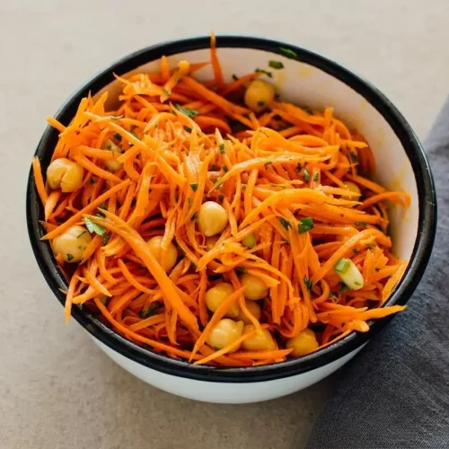 Grated carrot salad with fresh parsley, chives, and chickpeas in a glossy lemon Dijon dressing.