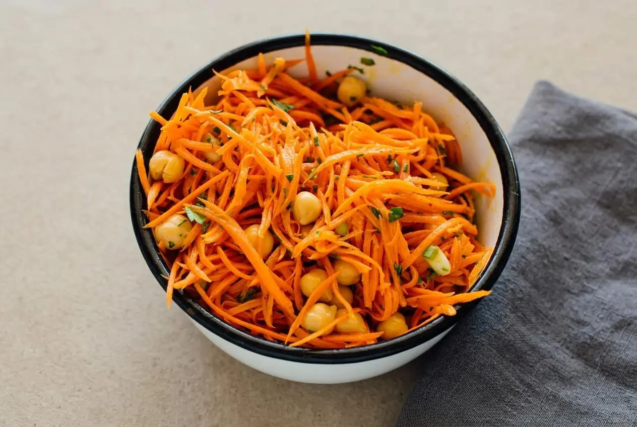 Grated carrot salad with fresh parsley, chives, and chickpeas in a glossy lemon Dijon dressing.