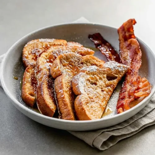 Golden brown french toast recipe slice on a plate with tender custardy center and crisp buttery edges.