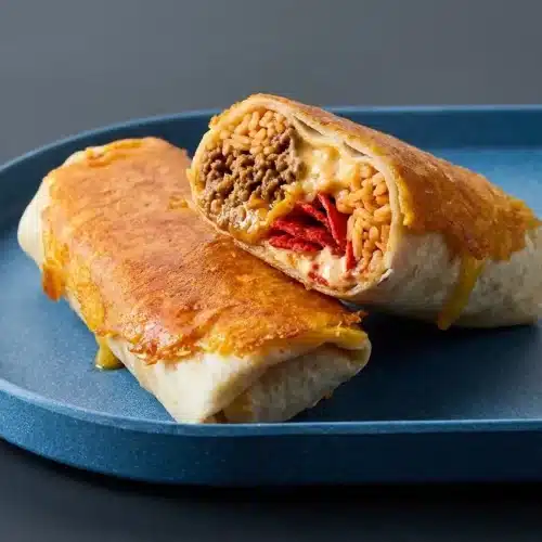 A golden-brown grilled cheese burrito with a crispy, lacy cheddar crust and a rich, warm beef and rice filling.