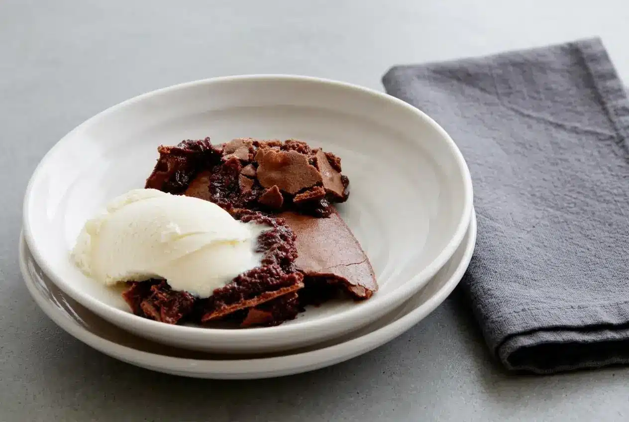 Baked Ina Garten brownie pudding in an oval dish with a crisp cocoa crust and molten chocolate center.