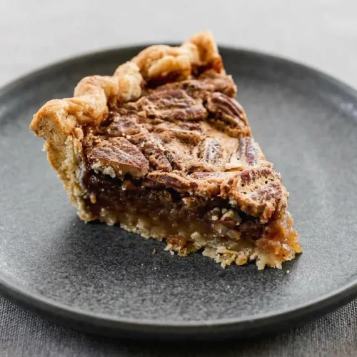 Pecan pie recipe with a flaky golden crust, glossy caramel filling, and toasted pecan halves.