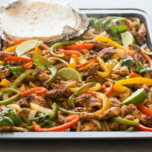 Sizzling sheet pan chicken fajitas recipe featuring tender roasted chicken, caramelized bell peppers, and charred onions.