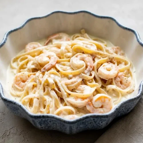 Shrimp alfredo with tender pink shrimp tossed in glossy garlic cream sauce over fettuccine.