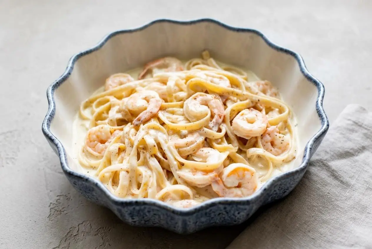 Shrimp alfredo with tender pink shrimp tossed in glossy garlic cream sauce over fettuccine.