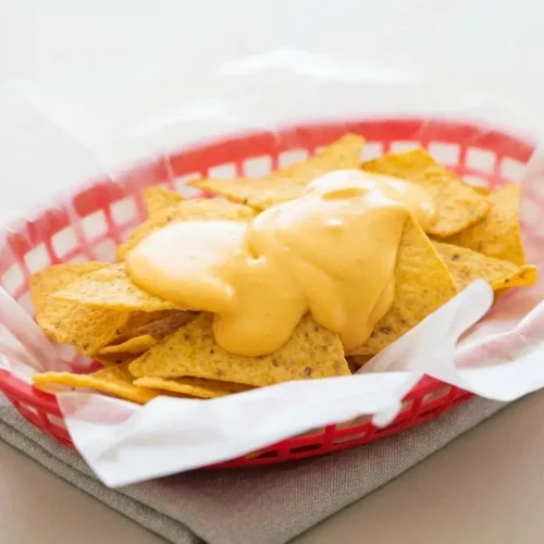 Warm, velvety nacho cheese sauce with a rich glossy finish served in a bowl.