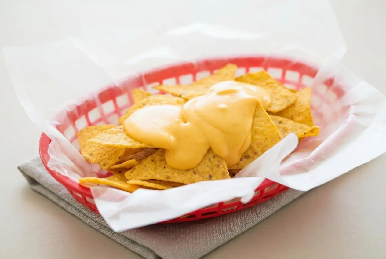 Warm, velvety nacho cheese sauce with a rich glossy finish served in a bowl.