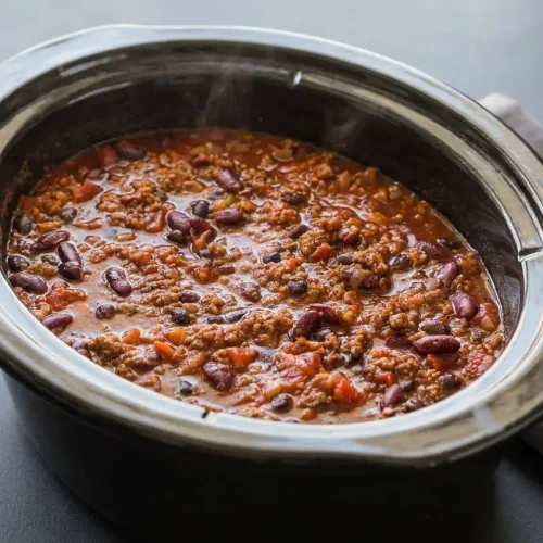 Thick slow cooker chili recipe with ground beef, kidney beans, and black beans in a rich tomato broth.