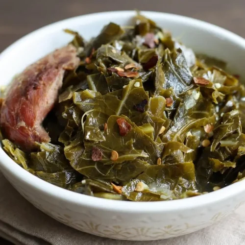 A bowl of tender collard greens recipe with shredded smoked turkey in a rich, savory broth.