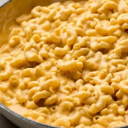 Bowl of creamy velveeta mac and cheese with a rich, glossy cheddar sauce coating tender elbow pasta.