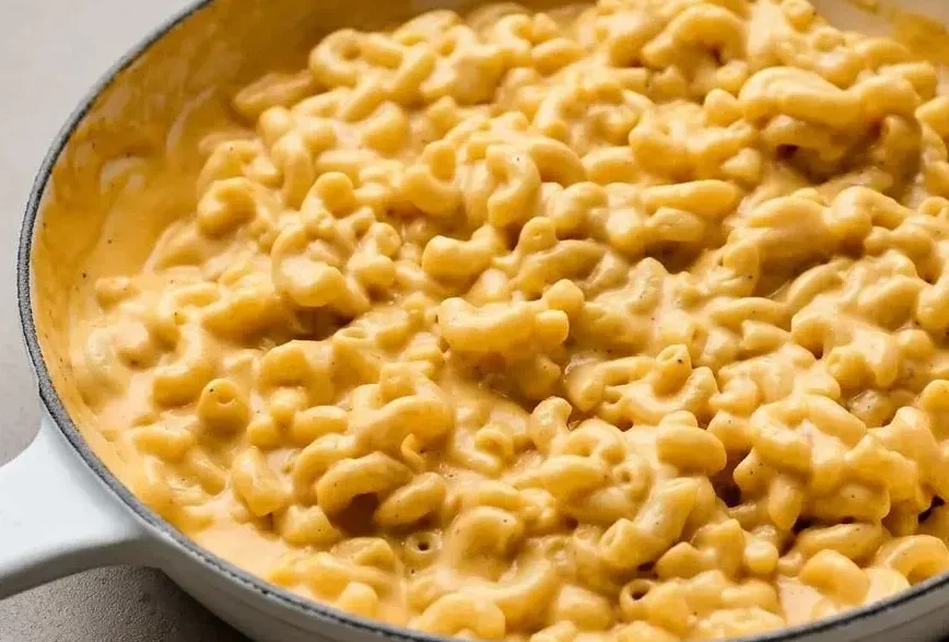 Bowl of creamy velveeta mac and cheese with a rich, glossy cheddar sauce coating tender elbow pasta.