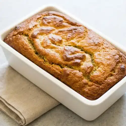 Golden-brown almond flour banana bread loaf with a tender, moist crumb on a wire rack.