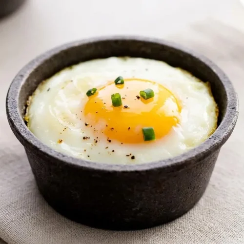 Baked eggs in a muffin tin with tender whites and glossy golden yolks.