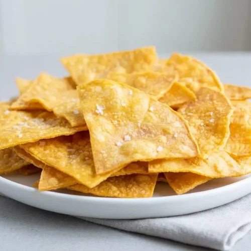 Crisp baked tortilla chips with golden toasted edges and a light sprinkle of sea salt flakes.