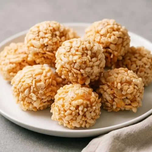 Crispy caramel marshmallow rice krispie balls showing a golden puffed cereal coating.